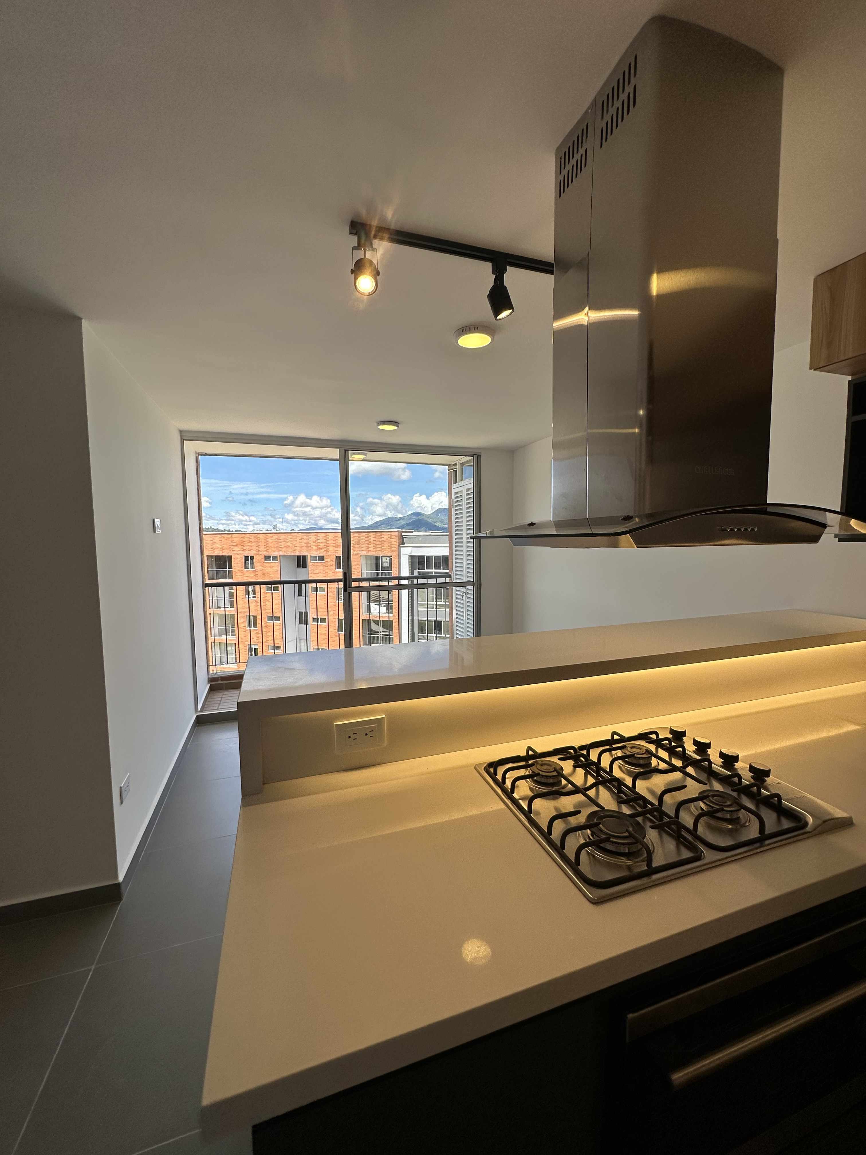 Cocina con barra iluminada y acabados Proyectos Dainco